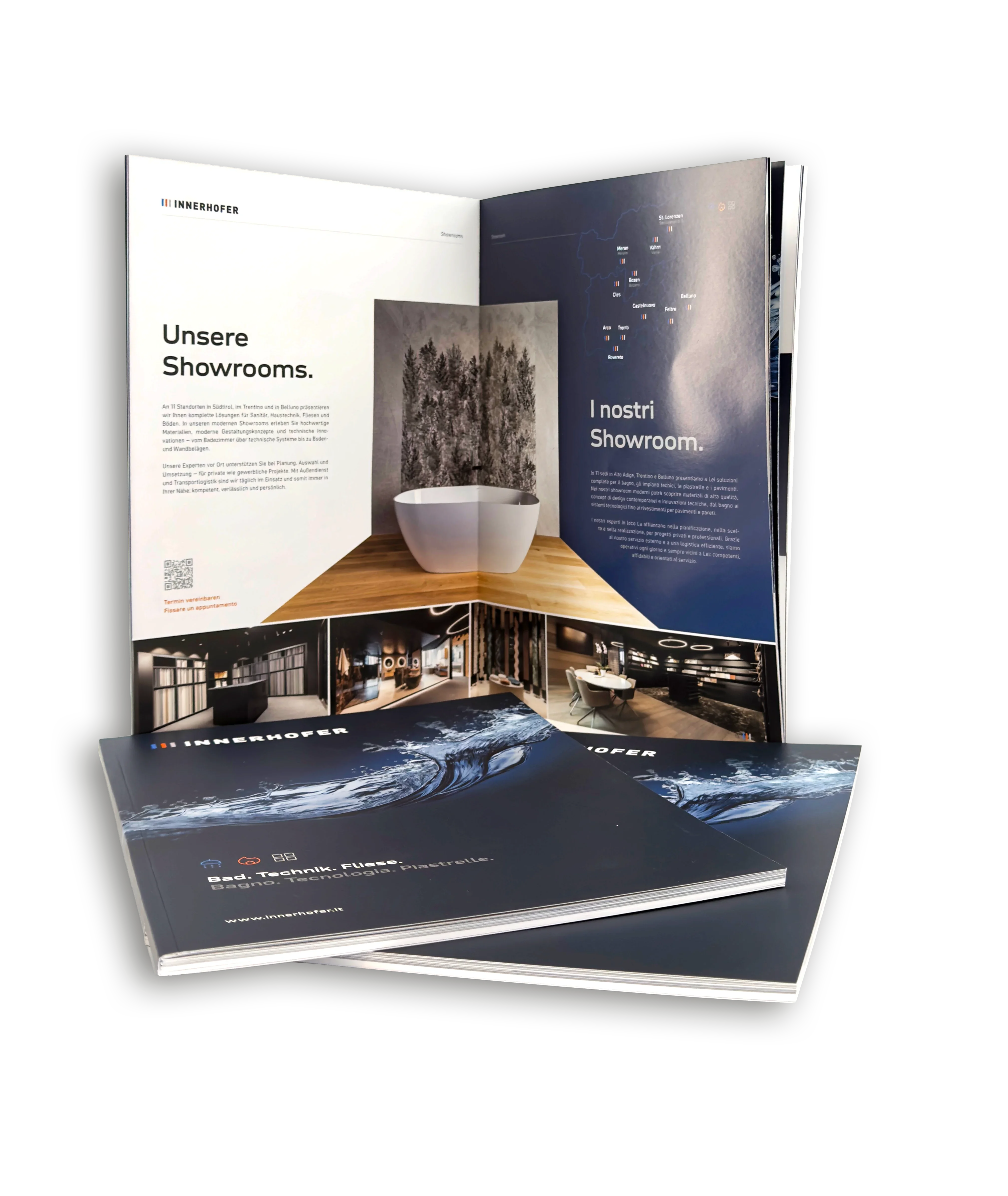 Ein aufgeschlagenes Magazin zeigt Seiten mit dem Titel "Unsere Showrooms" und "I nostri Showroom" in zwei Sprachen. Ein Foto von einer modernen Badewanne und stilvoll gestalteten Innenräumen ist sichtbar. Zwei weitere geschlossene Magazine liegen davor gestapelt.