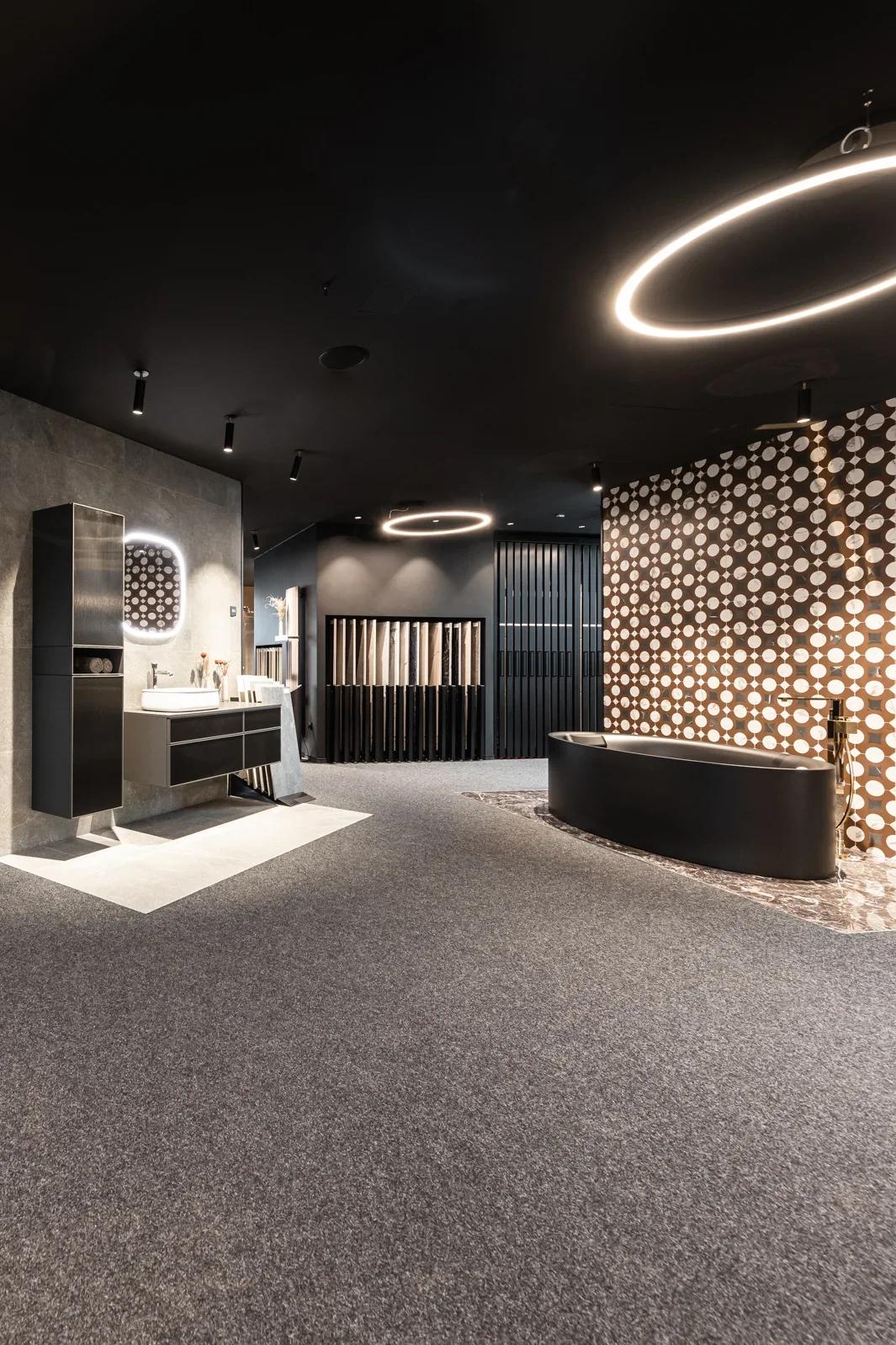Ein modern gestalteter Innenraum mit stilvollen Wänden in geometrischen Mustern. Der Raum ist mit eleganter Beleuchtung, einer Badewanne und Designerwaschbecken ausgestattet. Dunkler Teppichboden und stilvolle Dekorationen verleihen dem Raum ein luxuriöses Ambiente.
