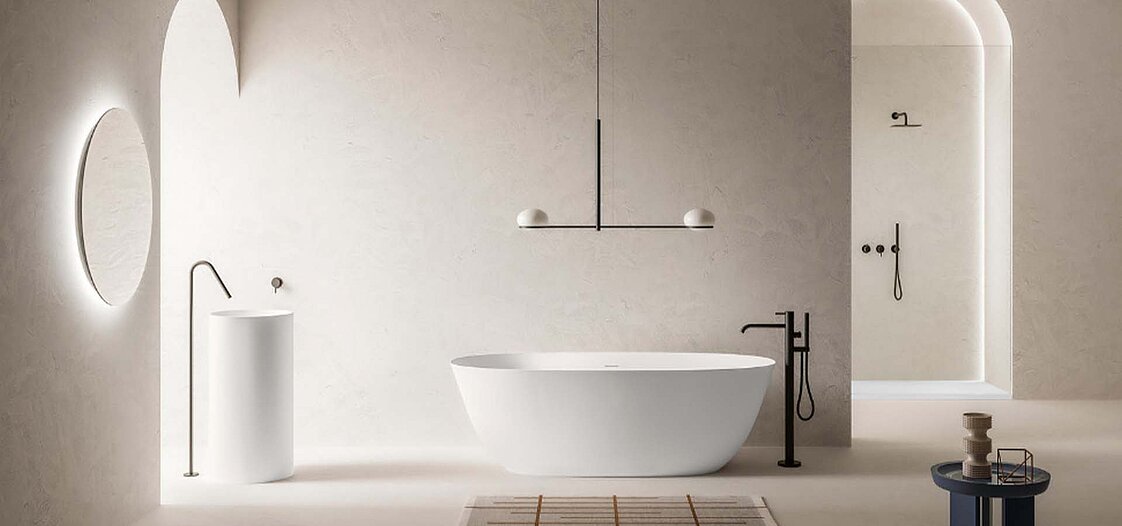 Ein Foto von einer modernen freistehenden Badewanne in einem beigen Raum.