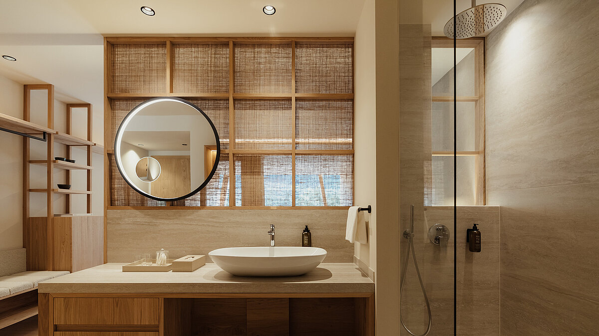 Modernes Badezimmer mit Holzmöbeln, einem runden Spiegel über einem Waschbecken und einer geräumigen, gläsernen Duschkabine rechts. Die Beleuchtung ist warm und einladend, betont durch natürliche Materialien wie Holz und Stein.